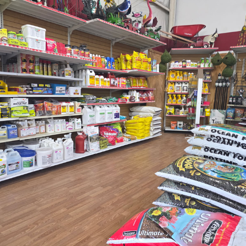 Shelves filled with gardening supplies, including fertilizers, seeds, and tools, line the walls of a well-organized store. Bright and colorful packaging creates a vibrant and inviting atmosphere.